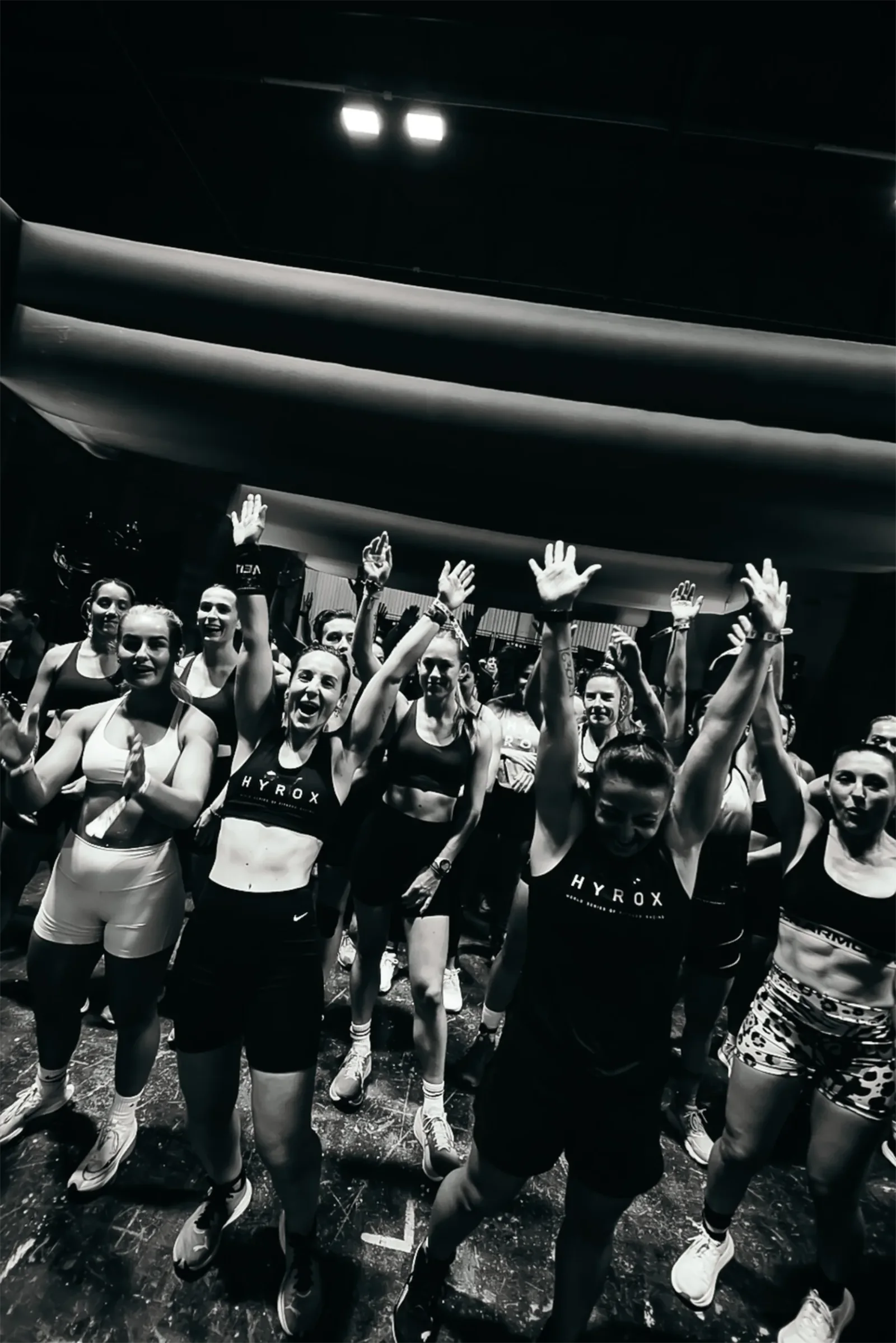 Grupo de participantes celebrando juntos en una competición HYROX.