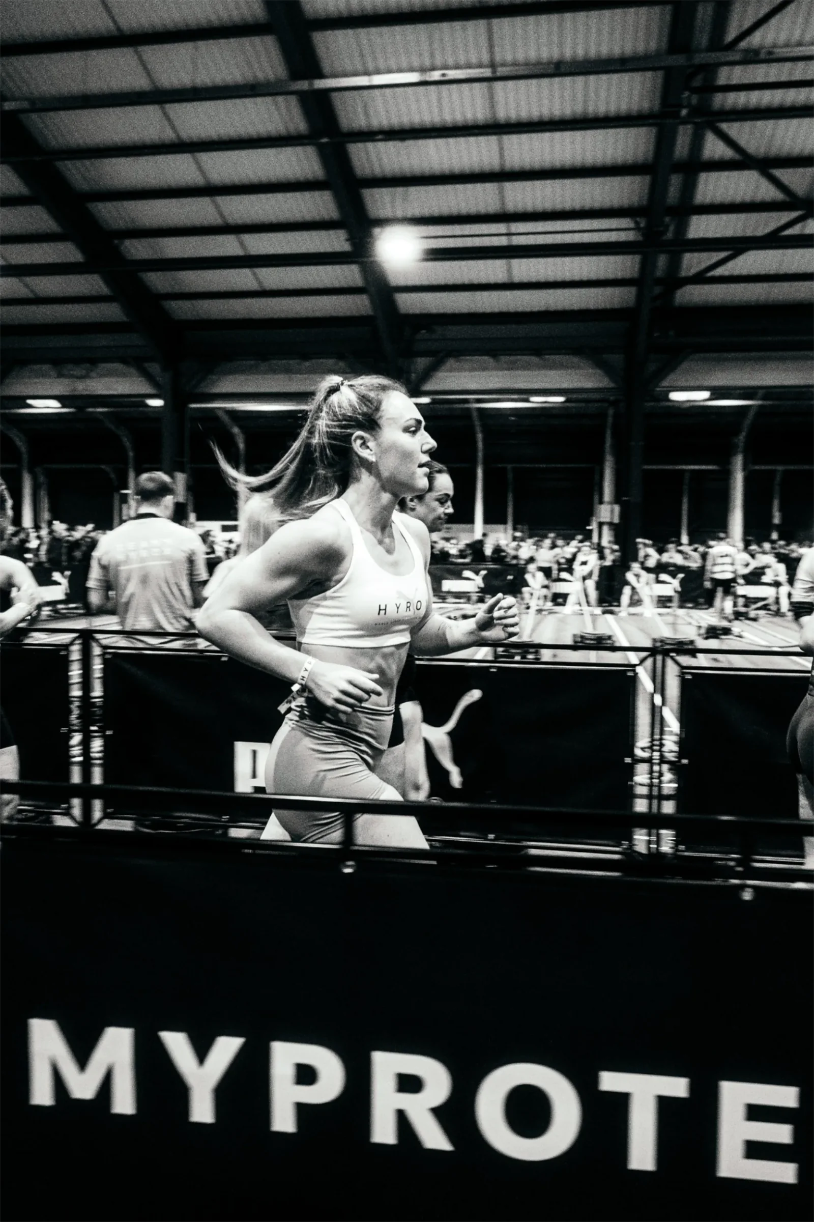 Atleta corriendo junto al circuito de una competición HYROX.